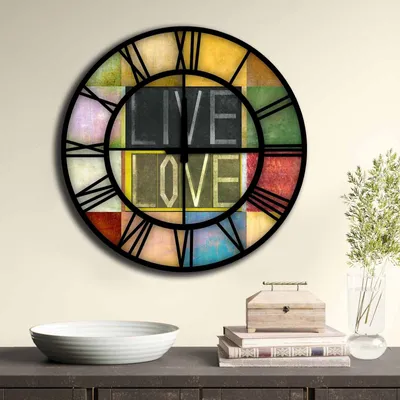 A colorful wall clock with the words "LIVE LOVE" in the center, displayed on a wall above a shelf with decorative items.