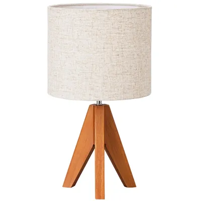 A table lamp with a beige fabric shade and a wooden tripod base.