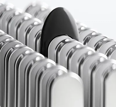 A close-up view of a black object among many silver objects, suggesting a single distinct item within a group.