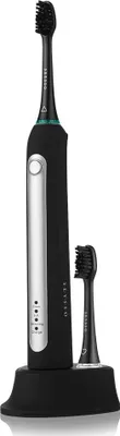 A black electric toothbrush with a charging base and an extra brush head, presented against a white background.