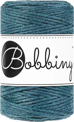 A spool of teal-colored macrame cord with a white label featuring the brand name 'Bobbiny' in black script.