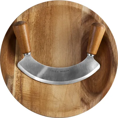 A wooden cutting board with a curved knife resting on it.