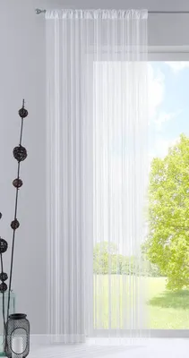 A white sheer curtain hangs in front of a window with a view of trees and sky.