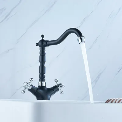 A black and silver faucet with water running into a white sink.