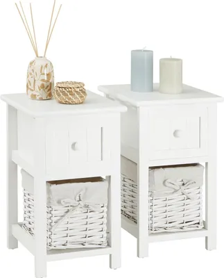 Two white bedside tables with drawers and baskets are shown against a white background.