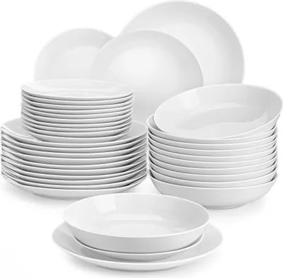 A collection of white ceramic plates and bowls stacked neatly.