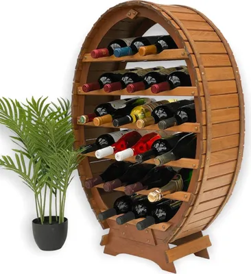 A wooden barrel-shaped wine rack filled with wine bottles, placed next to a potted plant.