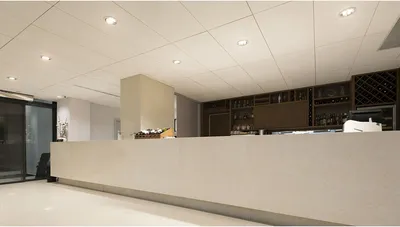 A modern reception area with a long counter and a bar in the background.