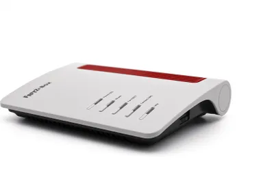 A white and red AVM FRITZ!Box 7510 WLAN router is shown from a side angle against a white background.