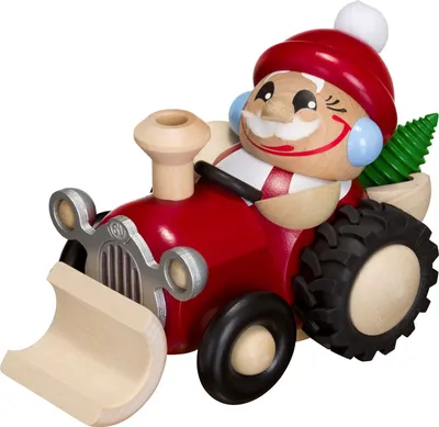 Ein fröhlicher Weihnachtsmann in einem rot-weißen Anzug fährt auf einem hölzernen Traktor mit einem kleinen grünen Baum auf der Ladefläche.