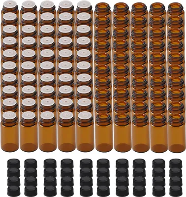 A collection of small amber glass bottles with white caps and a separate pile of black caps.