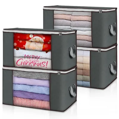 Four stacked storage boxes filled with folded clothes, with one box showing a Christmas theme.