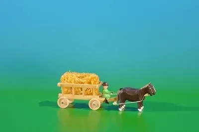 Productafbeelding van Miniatuur wagen met stro, met koetsier, naturel. Afmetingen: 9 x 3,5 cm. Nieuw