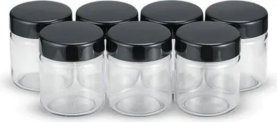 A group of glass jars with black lids.