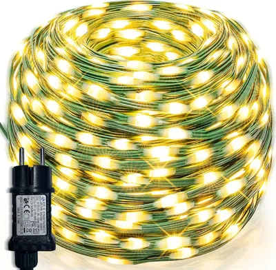 A coiled string of warm white LED lights with a green wire and a power adapter.