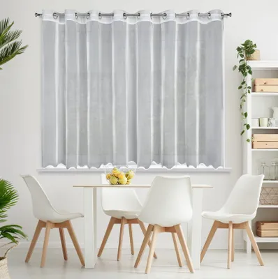 A white sheer curtain hangs over a window, with a dining table and chairs in front of it.