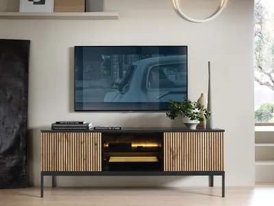 A modern living room with a TV mounted above a media console.