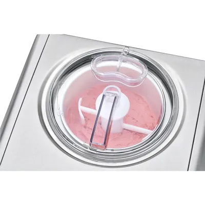 Close-up view of an ice cream maker with pink ice cream being churned.