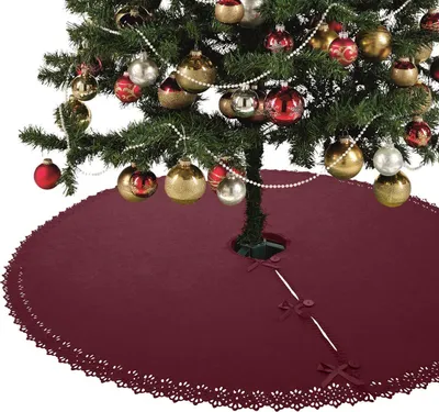 A Christmas tree decorated with ornaments and a red tree skirt.