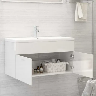 A white bathroom vanity with the doors open, showing storage space and some toiletries.