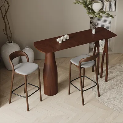 A bar table with two stools in a modern interior setting.