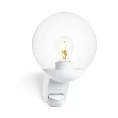 A white outdoor sensor light with a clear globe and a visible bulb.