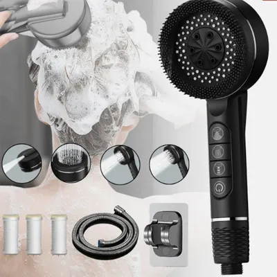 A person is using a black shower head with a brush attachment to wash their hair, which is covered in shampoo. The image also shows various components of the shower head set.