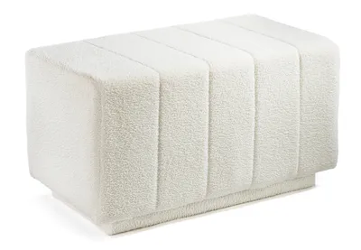 A white bouclé fabric bench or ottoman is shown against a white background.