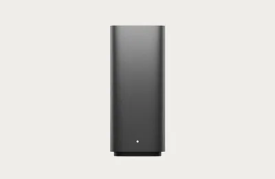 A dark gray rectangular electronic device with a small white indicator light on its base, set against a plain light gray background.