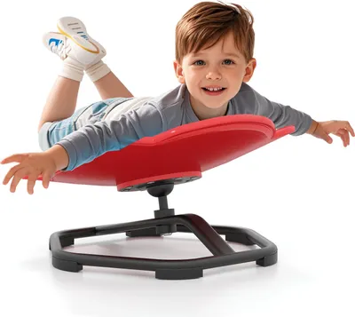 A young boy is lying on a red sensory swivel chair.