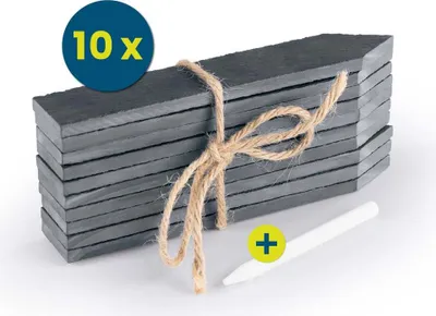 A stack of slate plant markers tied with twine, with a chalk pen next to them.