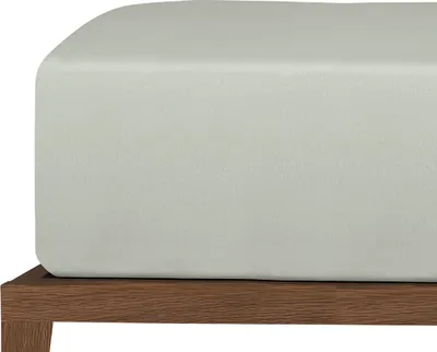 A close-up view of a fitted sheet on a bed frame.