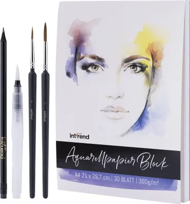 A watercolor paper block and art supplies are laid out on a white background.