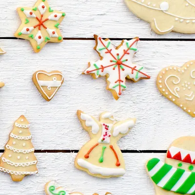 A collection of Christmas-themed cookies arranged on a white wooden surface.