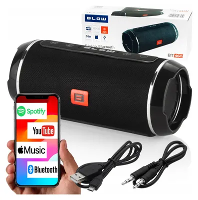 A hand holding a smartphone displaying music apps next to a Bluetooth speaker and its accessories.