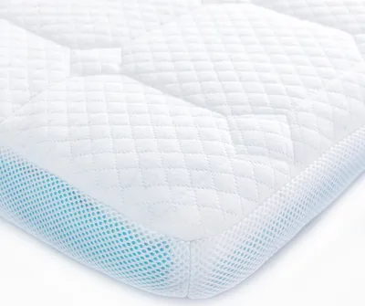 A close-up, angled view of a white mattress topper with a quilted pattern and a blue mesh side.