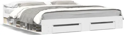 A white bed frame with storage drawers and shelves, shown with bedding.