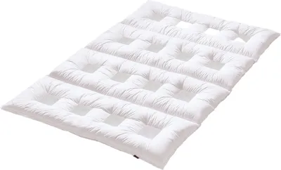 A white quilted mattress topper or duvet is shown from a diagonal angle against a white background.