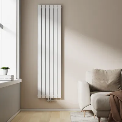 A vertical panel radiator is mounted on a light beige wall next to a window. A sofa with a throw blanket is visible on the right.