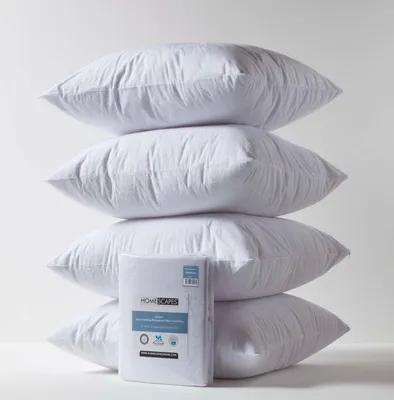 A stack of four white pillows with a packaged set of pillow protectors in front of the bottom pillow.