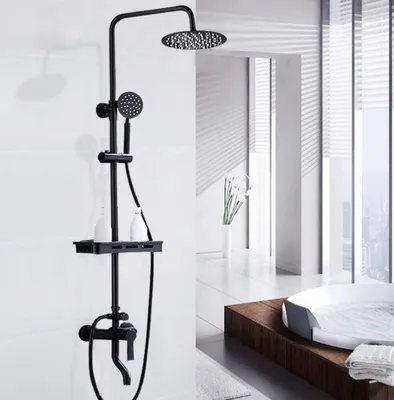 A black shower fixture set with a rainfall showerhead, handheld shower, and shelf, displayed in a modern bathroom setting with a bathtub in the background.