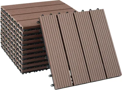 A stack of brown composite deck tiles with a few tiles laid out in front.
