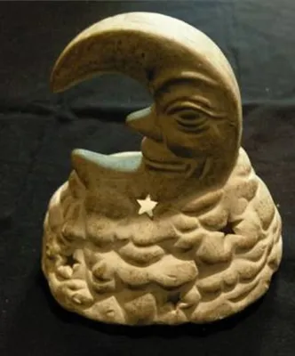 Eine Windlichtfigur in Form eines Mondes mit menschlichen Gesicht. Die Farbgebung ist erdig und warm