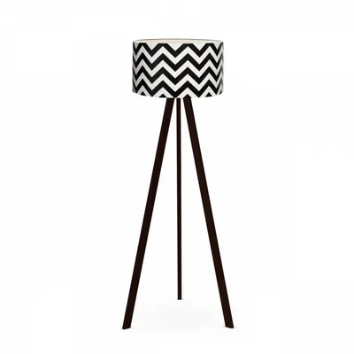 A floor lamp with a black and white chevron patterned lampshade and a dark brown tripod base, isolated on a white background.