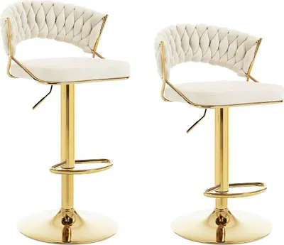 Two cream-colored bar stools with gold metal frames and bases are shown against a white background.