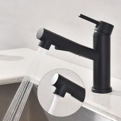 A black kitchen faucet with water spraying from its nozzle, shown in a close-up view over a sink.