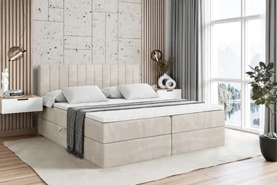 A bedroom scene featuring a bed with a headboard, mattress, and topper, flanked by nightstands and a large window with a view of a lake and mountains.