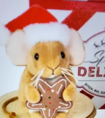 A plush toy mouse wearing a Santa hat and holding a gingerbread cookie.