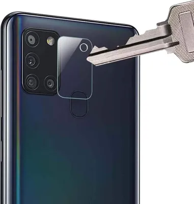 A close-up shot of a smartphone camera lens protector being demonstrated with a key.