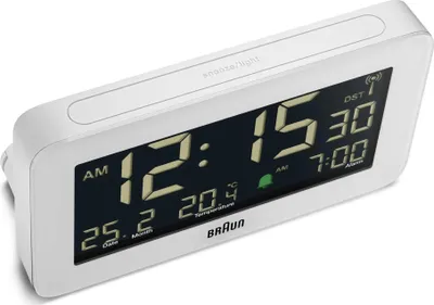 A white digital alarm clock with a black display showing the time, date, and temperature.